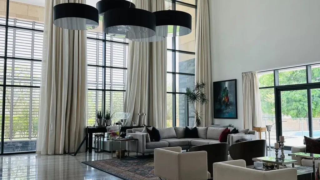 Motorized drapery across full height windows in a modern residence