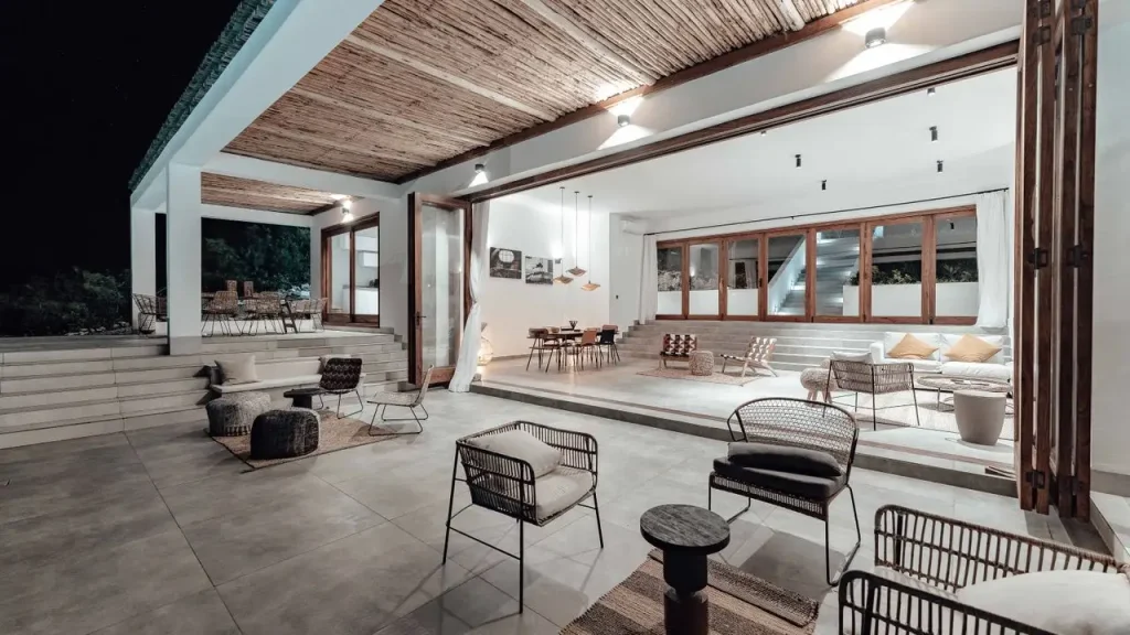 Retractable screens across an open air lounge with slatted roof