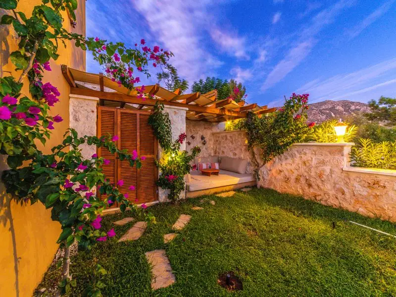 Garden terrace shaded by a retractable awning at twilight